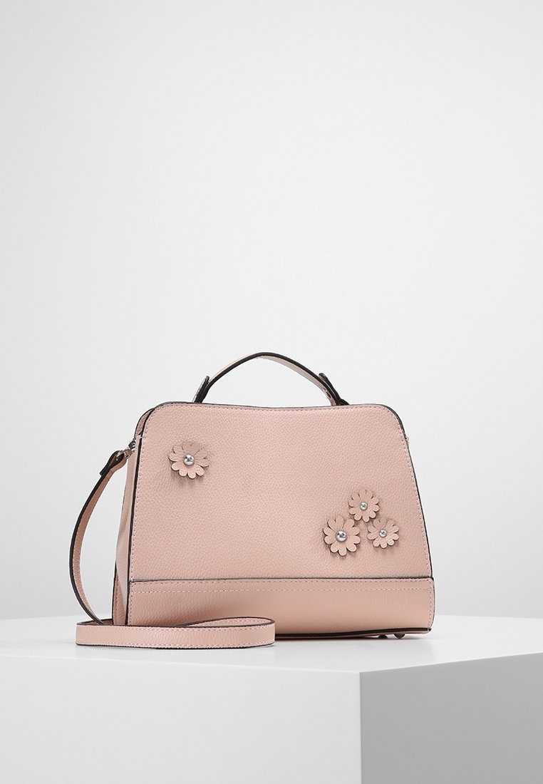 Rosa texturerad handväska med en strukturerad design, med tre blommiga applikationer och justerbar axelrem. Svart kant och hårdvaruaccenter.