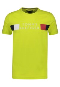 Camiseta de algodón amarilla neón con mangas cortas; presenta acentos en azul marino, blanco y rojo en el pecho y texto "TOMMY HILFIGER" en impresión en negrita.