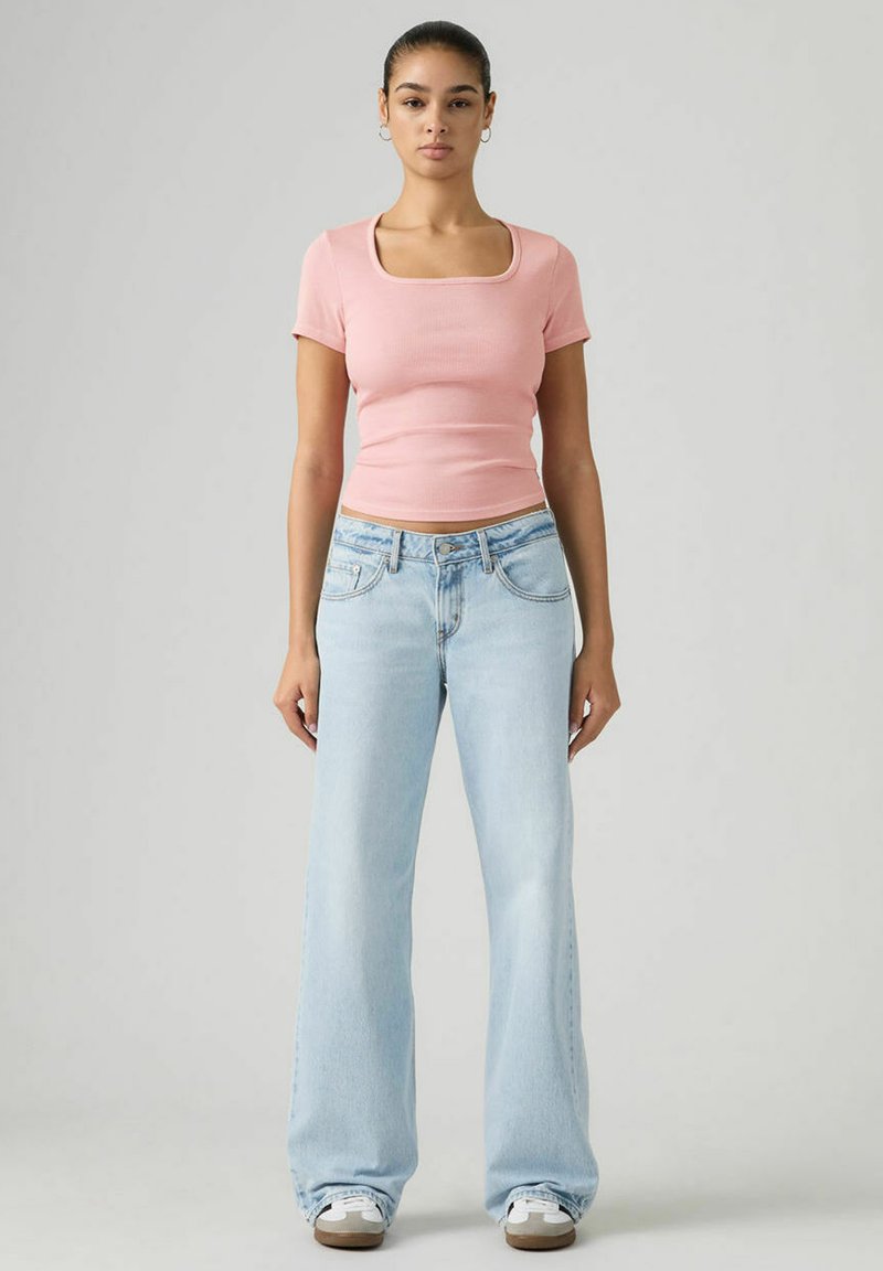 Pink ribbed short-sleeve top with a square neckline paired with light blue wide-leg jeans. Material appears soft and slightly stretchy.