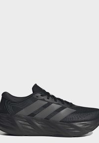 Black running shoe with textured sole and three dark gray stripes on the side, shown from the outer side on a plain background.
