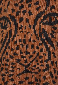 Knit fabric in brown with a black abstract pattern, featuring a textured, woven appearance. The design is intricate with varied shapes.