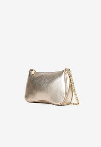 Bolso de mano metálico dorado con acabado texturizado, forma curva y correa de cadena dorada. Cuenta con un cierre de cremallera y elementos de diseño minimalistas.