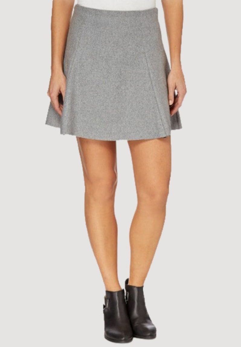 Falda gris acampanada hecha de una mezcla de lana, con una textura suave y pliegues a lo largo de la cintura, combinada con botines negros hasta el tobillo.