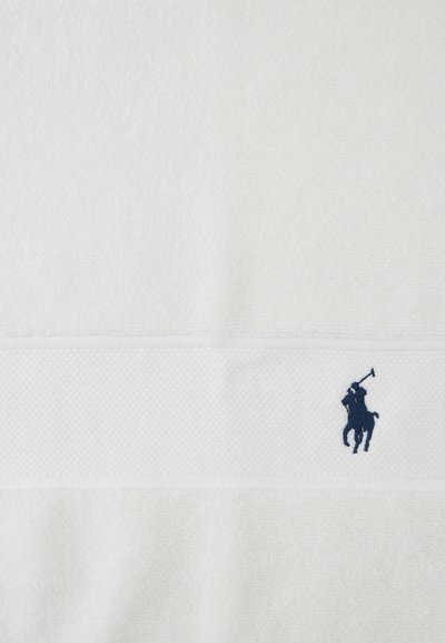 White towel with textured band and small navy blue embroidered polo player logo on horse holding mallet.