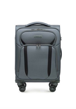 Grauer Hartschalenkoffer mit strukturiertem Oberflächendesign, zwei Reißverschluss-Vordertaschen und schwarzen Akzentgurten. Ausgestattet mit vier drehbaren Rollen und einem Griff oben.