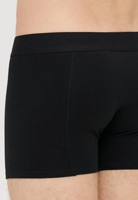 Sorte bomullsboxershorts med myk livlinning som har trykt merke, tettsittende snitt og glatt tekstur.