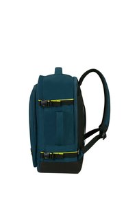 Zaino in tessuto turchese con finitura testurizzata, spallacci regolabili, pannello inferiore nero, fibbia laterale e webbing frontale per il fissaggio dell'attrezzatura.