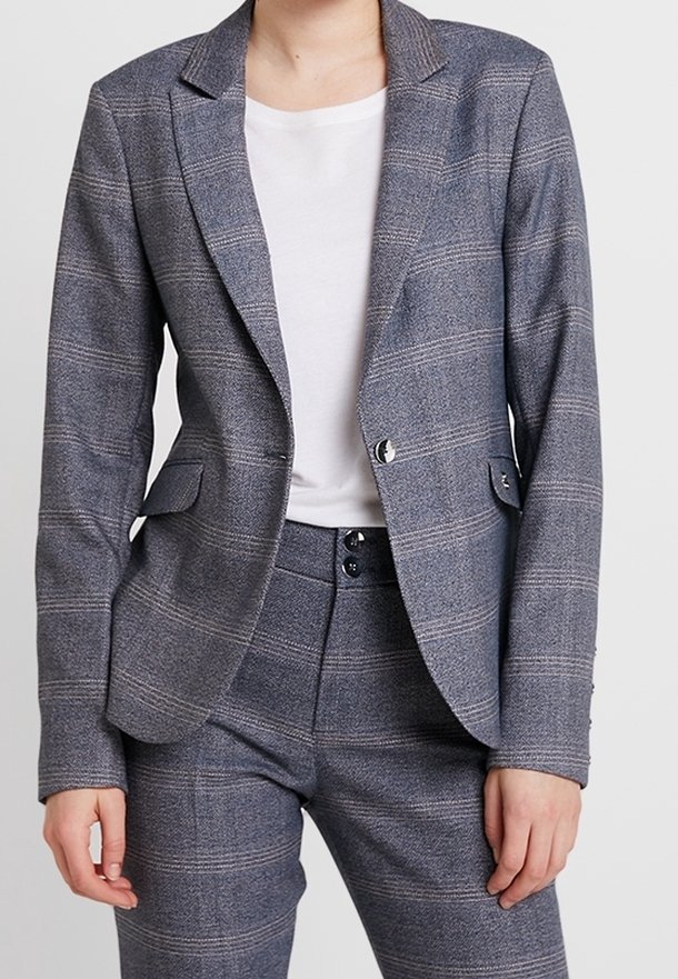 Grå rutigt kavaj med en strukturerad blazer med slag, två framsidor fickor, och matchande skräddarsydda byxor med knappar.