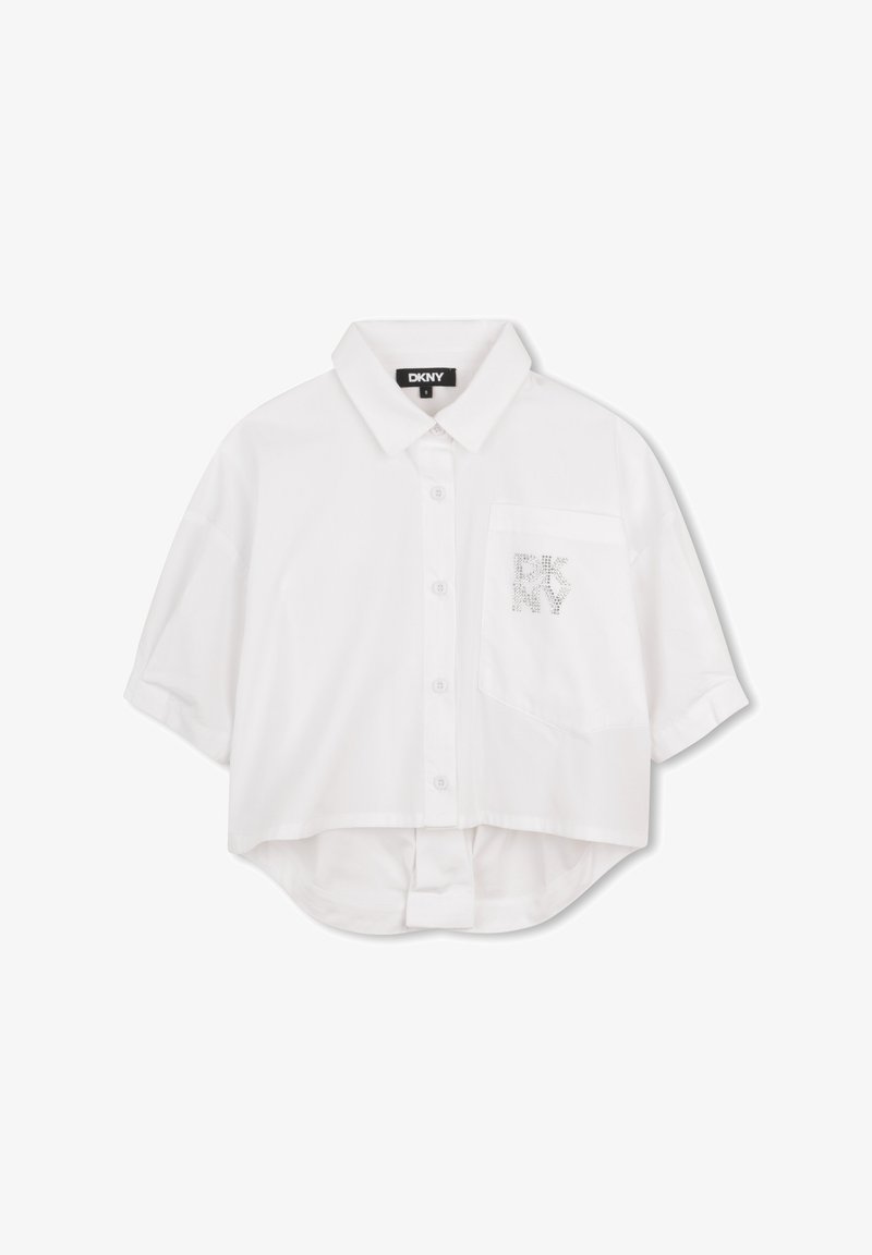 Chemisier blanc raccourci avec col rabattable, manches courtes, fermeture à boutons sur le devant et une poche ornée d'un logo DKNY en strass.