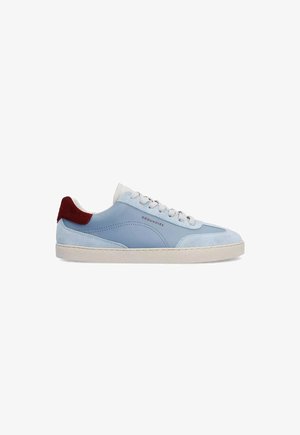 Sneaker bassa azzurro chiaro con lacci bianchi, suola beige, dettagli in camoscio e toppa sul tallone rosso scuro, con etichetta "GROUNDIES" sul lato.