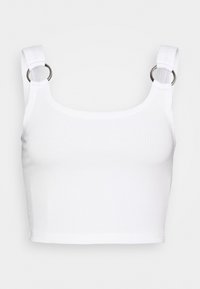 Top corto blanco de canalé con tirantes anchos que presentan detalles de anillos de metal plateado en cada hombro.