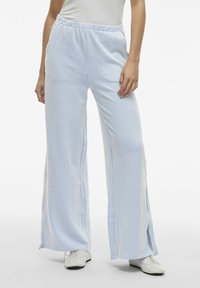 Blauw-witte geruite wijde broek met een relaxte pasvorm, voorzien van een elastische tailleband en zijslits, gemaakt van lichtgewicht stof.