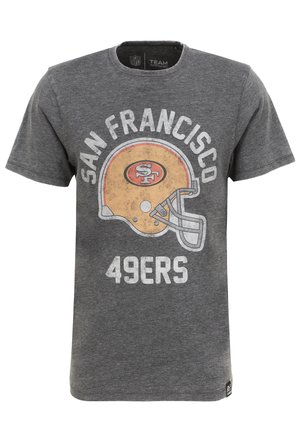 T-shirt en coton gris présentant un design des San Francisco 49ers, avec un casque de football jaune et un texte blanc en gras. Manches courtes et col rond.