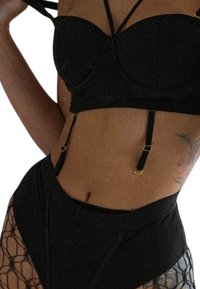 Schwarzes Unterwäsche-Set mit einem taillierten, gepolsterten Bralette mit verstellbaren Trägern und Strumpfhaltern, kombiniert mit einer hoch sitzenden, netzartigen Unterhose.