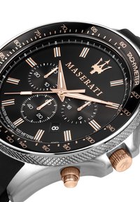 Orologio Maserati con quadrante nero e dettagli in oro rosa, tre sottodial, scala tachimetrica e cassa in acciaio inossidabile con cinturino in gomma nera.