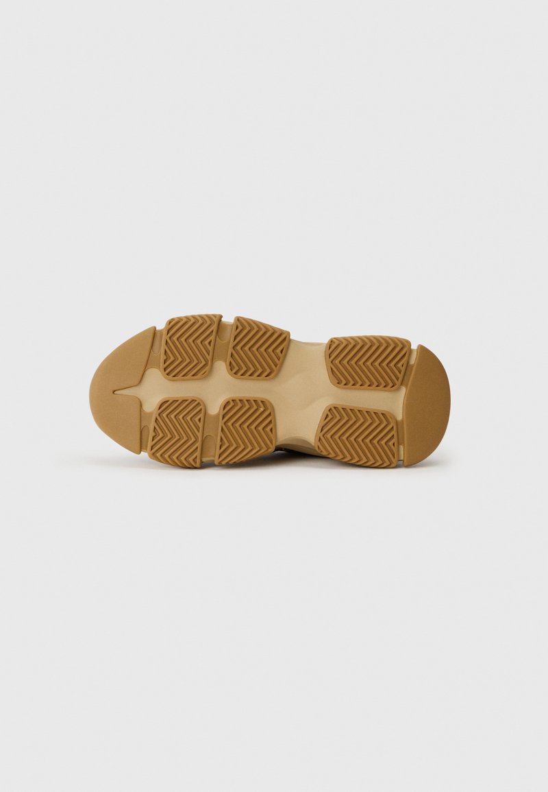 Sole in gomma di colore marrone chiaro con un evidente motivo a zigzag, punta arrotondata e bordi lisci. Spessa imbottitura per supporto.