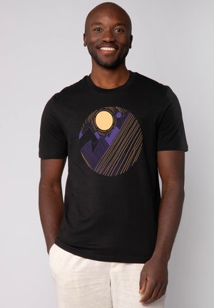 Schwarzes Kurzarm-T-Shirt mit einem kreisförmigen Grafikdesign, das eine gelbe Sonne, lila Berge und diagonale gelbe Linien zeigt. Baumwollmischgewebe.