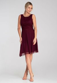 Burgunderfarbenes ärmelloses Kleid mit plissiertem Oberteil und dortigem Rock, mit einem knielangen Saum und weichem, glattem Stoff.