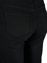Black denim jeans with a fitted shape, featuring two back pockets and subtle stitching. Material has a smooth, slightly textured finish.