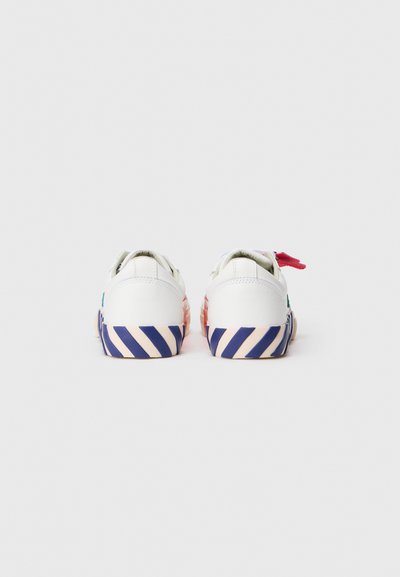 Witte sneakers met een gestructureerde bovenkant, met een meerkleurige gestreepte zool in roze en blauw. Inclusief een rode vetersaccent.