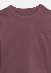 Κοντομάνικο, εφαρμοστό αθλητικό τοπ σε απαλό μαβί χρώμα, με ραβδωτή υφή και διακριτικές λεπτομέρειες ραφής, με μικρό μαύρο λογότυπο Nike κοντά στο τελείωμα.