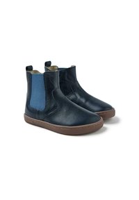 Botas de tobillo de cuero marino con paneles laterales elásticos, suelas de goma marrón y una textura suave. Cuenta con una pestaña para facilitar su colocación.