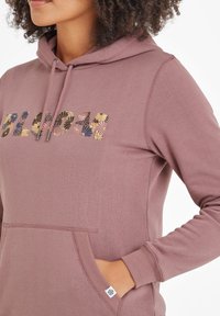 Hooded sweatshirt in mauve with a front pocket. 'BLOOM' is embroidered in floral patterns with various colors and textures.