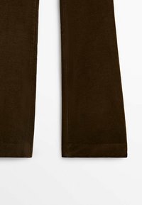 Pantalon en velours côtelé marron avec une texture douce, présentant un design à jambes droites et un léger côtelage vertical sur toute la surface du tissu.