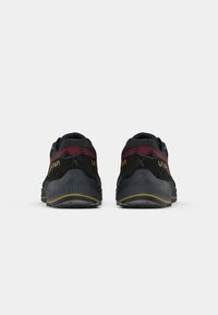 Pantofi sport negri și bordo cu un upper texturat, logo proeminent și un accent galben pe talpă. Vederea din spate evidențiază elementele de design.
