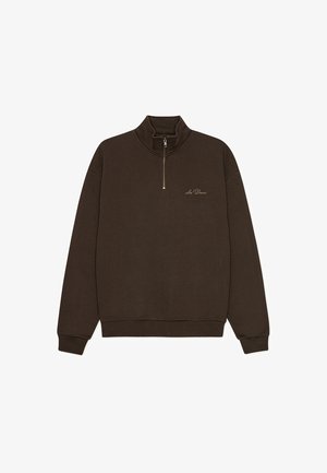 Pruun lukkuga pusa kõrge krae, soonikkoes varrukate ja alumise äärega. Rinnal on peen tikitud logo. Pehme puuvillane materjal.