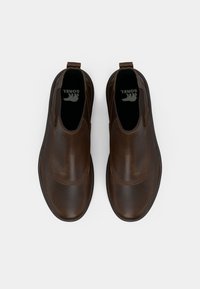 Chaussures slip-on en cuir marron avec des élastiques sur les côtés, bout rond et une semelle intérieure noire arborant un logo. Texture lisse avec une finition polie.