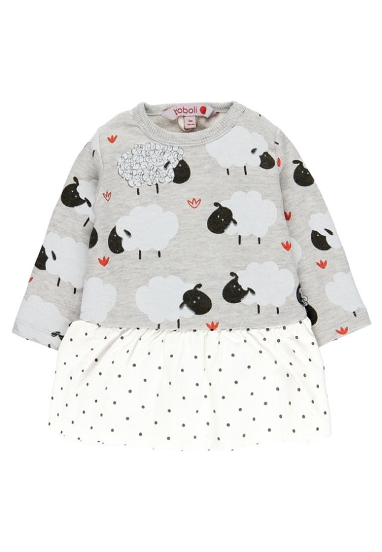 Vestido gris de manga larga con estampado de ovejas en la parte superior y falda blanca con lunares, que presenta detalles en flores rojas y una cintura fruncida.