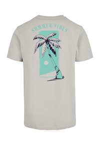 Light beige t-shirt featuring a palm tree graphic in teal and black with "SUMMER VIBES" text above, designed in a casual, relaxed style.
