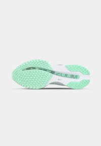 Semelle de chaussure Nike avec un motif de traction en caoutchouc vert menthe, une semelle intermédiaire blanche et un logo gris subtil au centre.