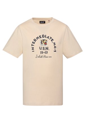 Beżowa koszulka z krótkim rękawem i okrągłym dekoltem, z grafiką ryczącego tygrysa oraz napisem „INTERMEDIATE MA-1 U.S.N. 19-13 Schott Bros inc” na przodzie.