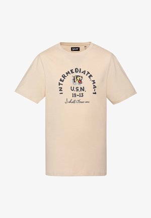 T-shirt beige à manches courtes avec col rond, arborant un graphisme de tigre rugissant et le texte « INTERMEDIATE MA-1 U.S.N. 19-13 Schott Bros inc » sur le devant.