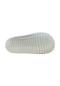 Suela de zapato de goma blanca con una superficie texturizada, que presenta un patrón de cuadrícula y acentos circulares cerca del área del dedo del pie. Tamaño marcado como 26.