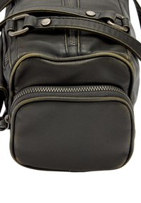 Czarna skórzana torebka na ramię z kontrastującymi szwami, zamykanymi na suwak przegródkami, teksturowaną powierzchnią i metalowymi akcentami.