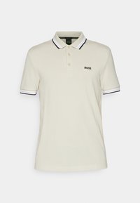 Polo beige en coton, avec une patte de boutonnage à trois boutons, col et poignets côtelés noir et blanc, avec logo "BOSS" brodé.