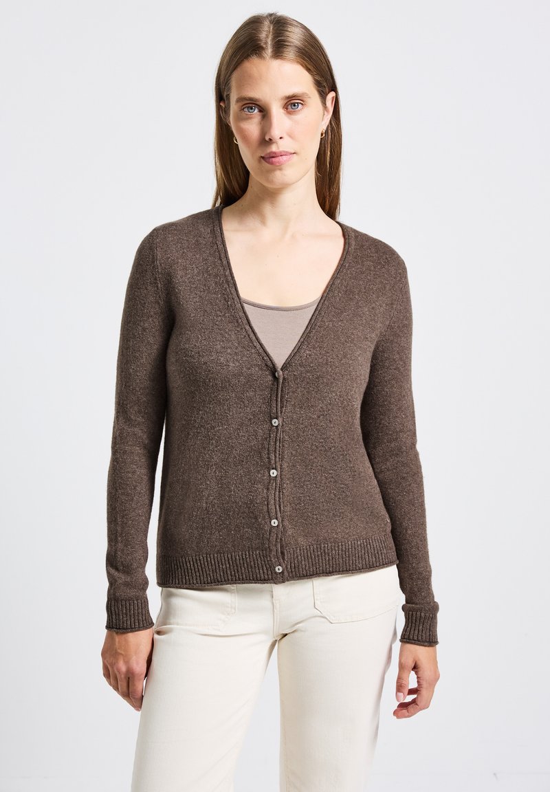 Brun stickad kofta med V-ringning, långa ärmar och ribbade manschetter. Har matchande knappar fram och ett texturerat tyg.