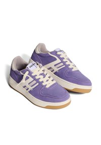 Sneaker in suede viola con suola in gomma crema, lacci bianchi e strisce laterali prominenti. Logo stampato sulla linguetta.
