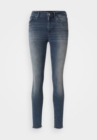 Jeans ajustados en denim azul oscuro, con efecto desgastado, diseño de cinco bolsillos y dobladillo sin acabar en el tobillo. Texturizados y ceñidos al cuerpo.