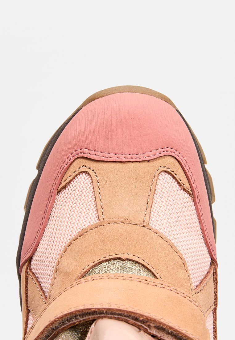 Rosa und beige Sportschuh mit einer strukturierten Oberseite aus Mesh- und Wildledermaterialien, einer runden Zehenpartie und einer Gummisohle.