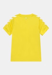 Gul kortærmet t-shirt med en glat tekstur. Har hvide dekorative striber på skuldrene og et lille logo over nakken bagpå.