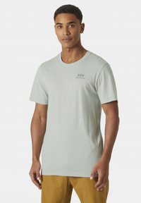Camiseta de algodón verde claro con cuello redondo y mangas cortas, con un discreto logo de Helly Hansen en gris en el pecho.