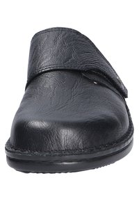 Chaussure noire en cuir à enfiler avec un dessus courbé et une surface texturée. Équipée d'une sangle à crochet et boucle pour un ajustement sécurisé et d'une semelle extérieure durable.