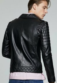 Zwarte leren motorjacket met gequiltte schouderdetails, slim fit en een klassiek kraagontwerp. Textuurfinish.