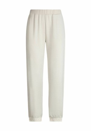 Pantalons de jogging en polaire couleur crème avec taille élastique et poignets élastiques, présentant un texte de marque subtil.