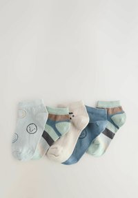 Quatre paires de chaussettes en coton dans des nuances de bleu, vert et beige ; présentant des motifs de smileys et des rayures, avec des motifs et textures variés.