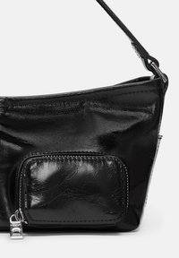 Bolso de mano de cuero negro con una textura lisa y brillante. Cuenta con un bolsillo frontal con cremallera y una correa delgada para llevar.